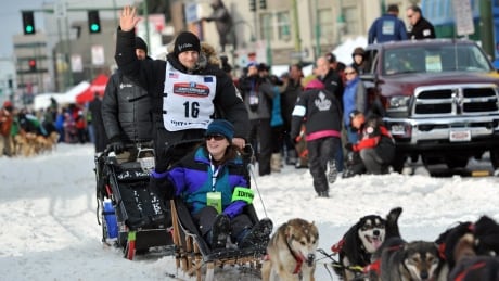 Defending Iditarod Trail Sled Dog Race champion Dallas Seavey (16) waves to the crowd as she begins the ceremonial start of the 1,600-kilometre race in Anchorage, Alaska, Saturday, March 5, 2016. Iditarod