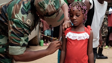 A Angolan military administers a yellow fever vaccine to a child at 'Quilometro 30' market, Luanda, Angola, 16 February 2016. This market in the Angolan capital was considered the center of the yellow fever outbreak killing 51 people out of 240 cases since December of 2015. Yellow fever