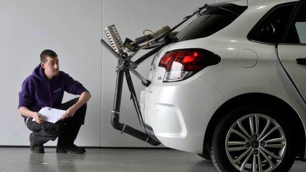 A worker monitors a vehicle during emissions testing at 'Emissions Analytics' in west London. German automakers are testing thousands of vehicles to make sure their diesel emissions management software is functioning.