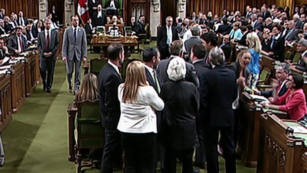 In a still image from House of Commons video, Prime Minister Justin Trudeau, centre-right, is seen reaching in for Conservative whip Gord Brown, centre, as NDP Leader Tom Mulcair, centre-left, stands by. The video shows the prime minister bumping NDP MP Ruth Ellen Brosseau, right.