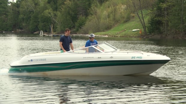 Two men take a boat ride on Lake McGregor in Val-des-Monts, Que.