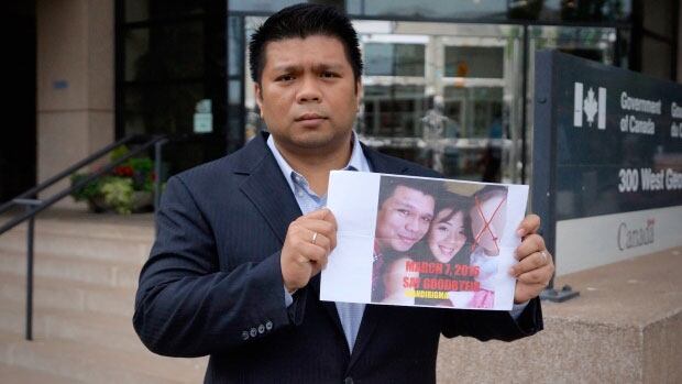 Lowell Menorca holds the image he claims a family member found on his car in the Philippines. He says the note prompted him to leave the country, and he is now seeking refugee status in Canada.