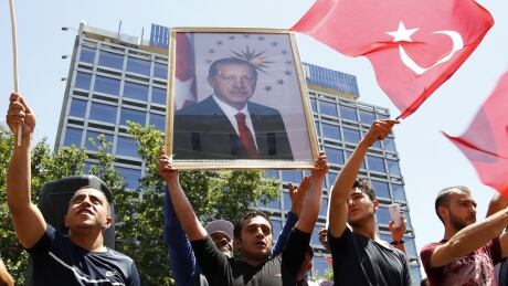 Supporters of Tukish President Tayyip Erdogan lift up his portrait as they celebrate with flags in Ankara, Turkey, July 16, 2016. REUTERS/Tumay Berkin TPX IMAGES OF THE DAY - RTSI9VV TURKEY-SECURITY/