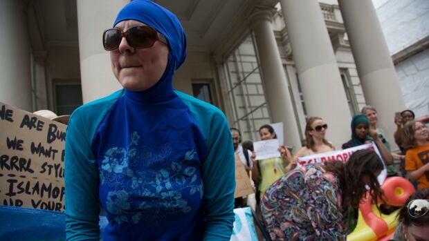 Women protest against the burkini ban on French beaches at the French embassy in London Thursday. A French court overturned local bans Friday.