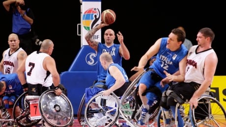 Italy's Alberto Pellegrini, centre, prepares to pass the ball as his teammate Matteo Cavagnini, second right, collides with Canada's Adam Lancia during the Wheelchair Basketball competition at the Paralympic World Cup in Manchester, England, Saturday May 29, 2010. (AP Photo/Jon Super). BRITAIN PARALYMPIC WORLD CUP