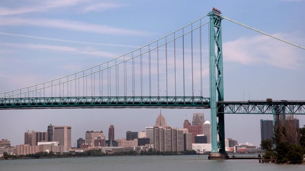 The Detroit city skyline is seen behind the Ambassador Bridge, an international border-crossing linking Windsor, Ont., with Detroit. Transport Canada has ordered the company responsible for the bustling border crossing to make emergency repairs.