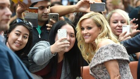 Reese Witherspoon takes a selfie with fans as she arrives at the Sing premiere at the Toronto International Film Festival at the Princess of Wales Theatre on Sept. 11, 2016, in Toronto. (Evan Agostini/Invision/AP) 2016 TIFF Reese Witherspoon selfie