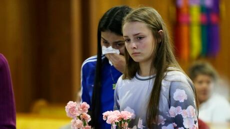 Rachel Marsh, 15, right, and Selena Orozco, 15, left, carry flowers as they attend a prayer service, Saturday, Sept. 24, 2016, at the Central United Methodist Church in Sedro-Woolley, Wash. The service was held in regard to Friday's fatal shooting of several people at a Macy's department store at the Cascade Mall in nearby Burlington, Wash. Both girls said they knew one of the victims of the shooting. (AP Photo/Ted S. Warren) APTOPIX Mall Shooting Washington