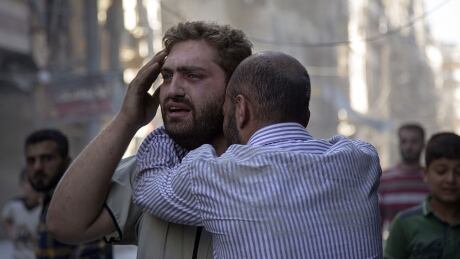 Syrians react as the bodies of children are pulled from the rubble of a building following government forces air strikes in the rebel held neighbourhood of Al-Shaar in Aleppo on September 27, 2016. AFP_GJ2W0