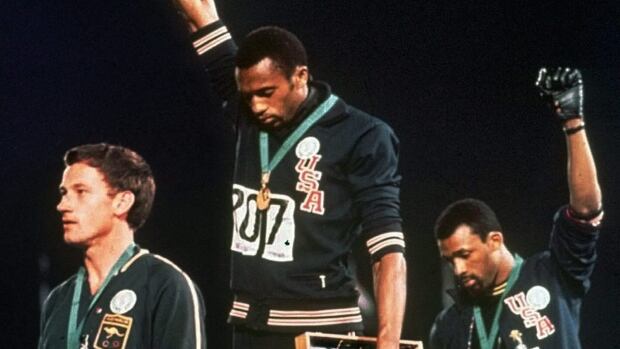 U.S. athletes Tommie Smith, centre, and John Carlos extend gloved hands skyward during the playing of the American national anthem at the 1968 Olympics in Mexico City.
USOC-Smith and Carlos
