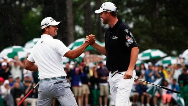 Adam Scott of Australia, left, is congratulated by compatriot Marc Leishman after sinking a birdie putt on the 18th green during final round play in the 2013 Masters golf tournament at the Augusta National Golf Club.