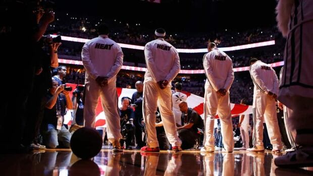 Miami Heat's LeBron James, second left, stands for the national anthem before his team plays the San Antonio Spurs in Game 7 of the NBA Finals on Thursday.