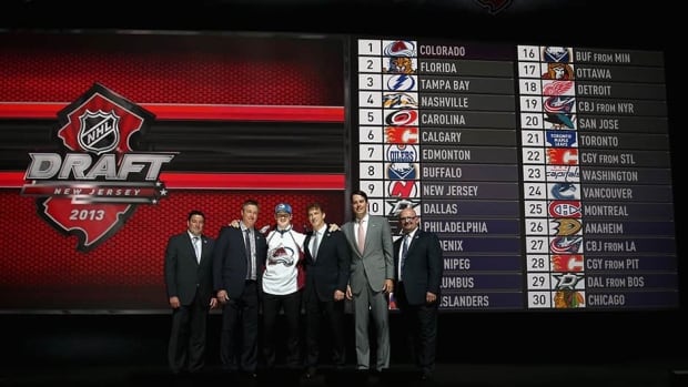 Nathan Mackinnon, centre, poses with head coach Patrick Roy, second left, and executive vice president of hockey operations Joe Sakic, second right, after being selected first overall in the NHL draft by the Colorado Avalanche on Sunday.