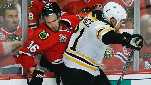 Chicago Blackhawks centre Marcus Kruger, left, collides with Boston Bruins defenceman Andrew Ference in the third period during Game 2 Saturday in Chicago.