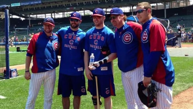 Teammates from the Stanley Cup champion Blackhawks Brandon Bollig, second from left, and Bryan Bickell, centre, pose with Cubs rookie Anthony Rizzo, right, at Wrigley Field in Chicago on July 5. Bollig and Bickell were on hand to take part in batting practice with the MLB team.