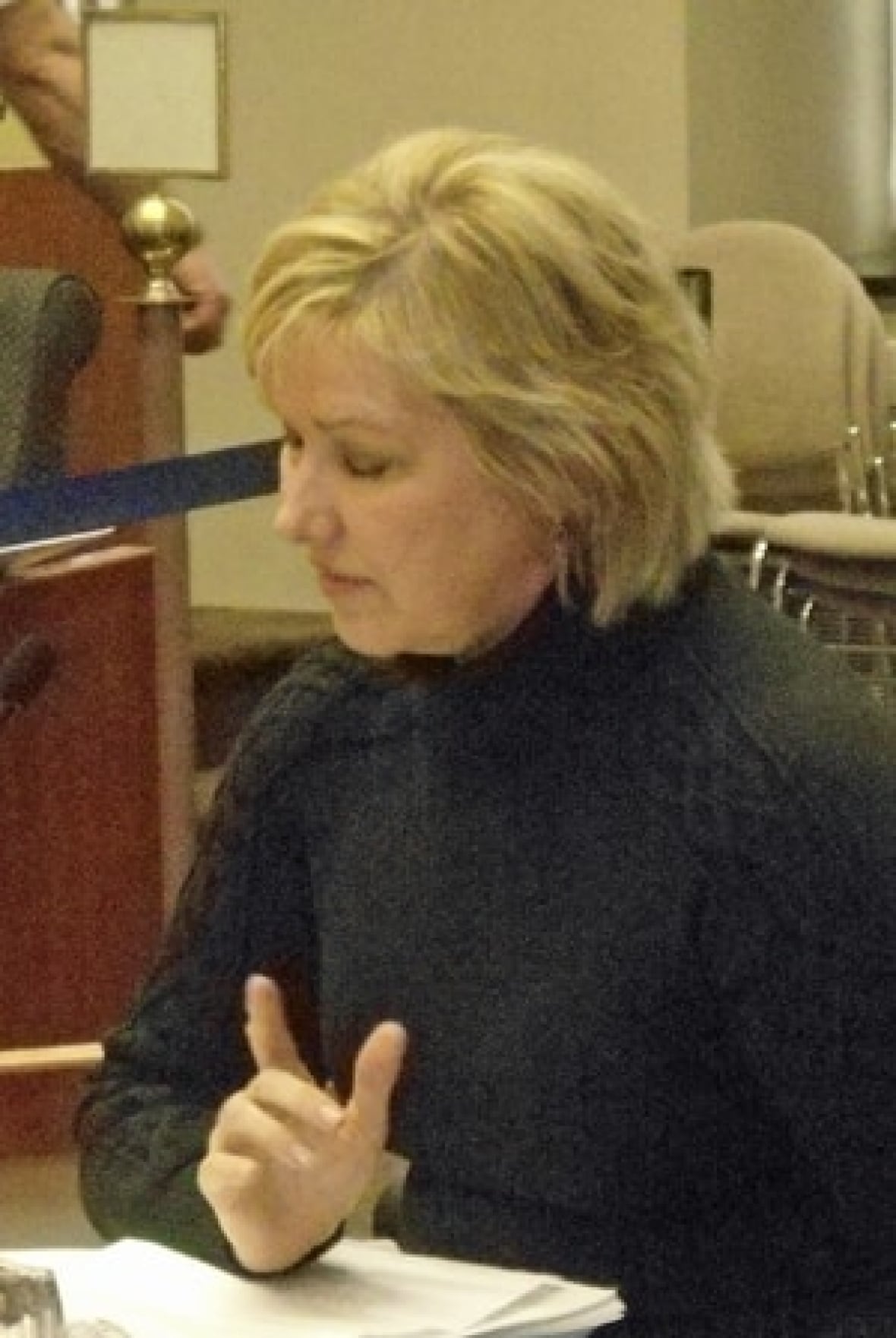 A woman looks down sat at a desk