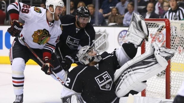 Goaltender Jonathan Quick (32) of the Los Angeles Kings makes a glove save on a shot by Patrick Kane (88) of the Chicago Blackhawks, not pictures, as Chicago's Bryan Bickell (29) battles with L.A.'s Dwight King (74) in Game 4 on Thursday.