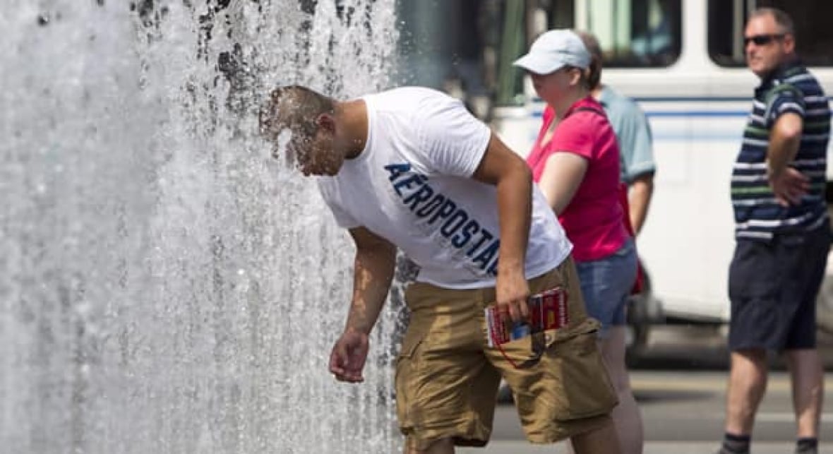 Person trying to cool down by the water fountain