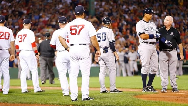 Alex Rodriguez, second from right, of the New York Yankees walks to first base with a trainer after being hit by a pitch in the 2nd inning by Ryan Dempster of the Boston Red Sox during the game on Sunday at Fenway Park. Both benches were warned and manager Joe Girardi of the New York Yankees was ejected.