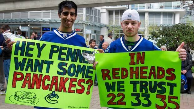 Paul Nagra, left, and Matthew Charron show off their signs outside Rogers Arena prior to the start of Game 5 in Vancouver.