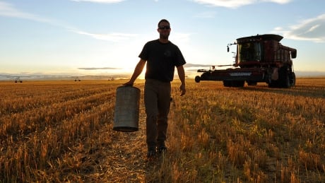 A worker carries an air filter during wheat harvest on the Stephen and Brian Vandervalk farm near Fort MacLeod, Alta. Alberta, Saskatchewan and Ontario saw the biggest jumps in price per acre for farmland this year. hi-farmtr2su0x-8col