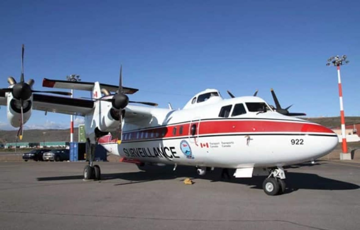 Un avion à hélices est stationné sur un tarmac dans la toundra canadienne.