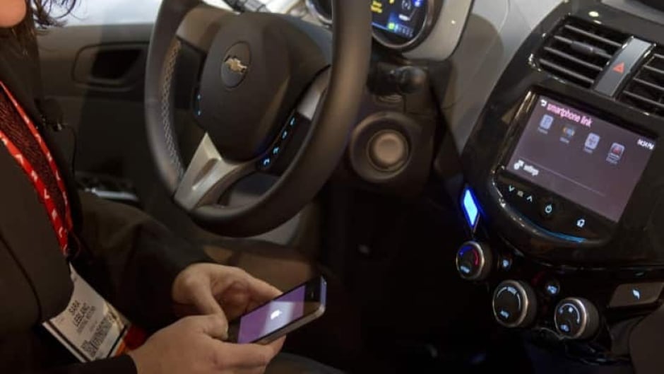 A woman links her iPhone to the MyLink system in a Chevrolet Spark. MyLink incorporates voice recognition software and can provide climate control, roadside assistance and vehicle diagnostics. (Steve Marcus/Reuters)
