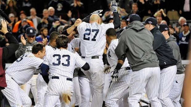 New York Yankees' Raul Ibanez (27) celebrates with teammates as he reaches home plate after hitting the game-winning home run during the 12th inning on Wednesday night.