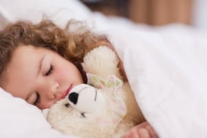 Girl sleeping with her teddy
