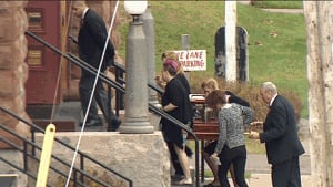 Genevieve Cormier's family carrying urn at funeral