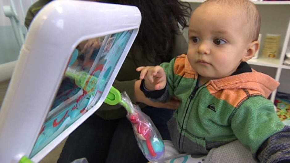 Toddler Kade Essay checks out the iPad holder on Fisher-Price's Apptivity seat. Should parents worry about how much screen time their children get?
