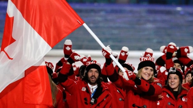 Hayley Wickenheiser carries the Canadian flag as she leads the team during the opening ceremony of the 2014 Winter Olympics in Sochi, Russia, Friday.
