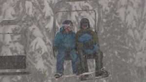 snowboarders riding chairlift