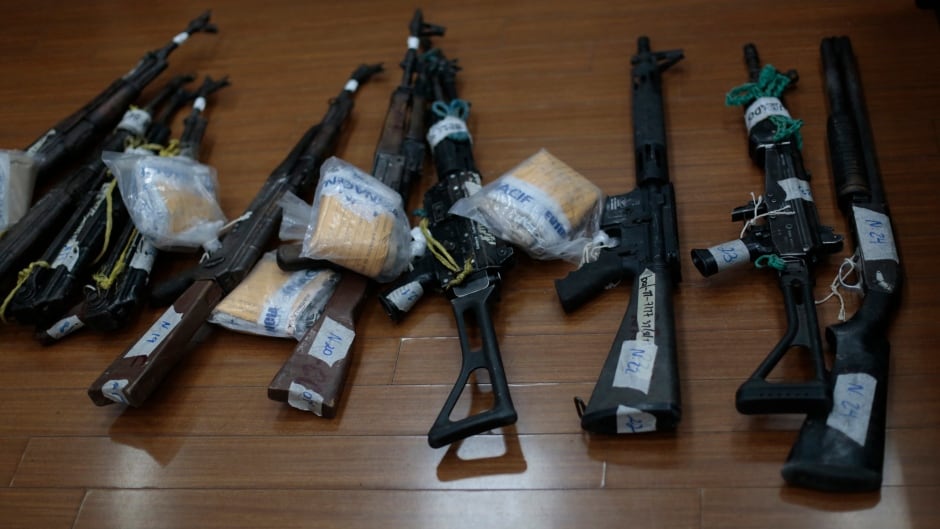 Weapons are displayed on the floor before being presented to a judge as evidence during a trial against nine alleged members of the Zetas drug cartel in the Supreme Court of Justice in Guatemala City, January 30, 2014. The nine are accused of killing 27 people during a territorial dispute on May, 2011, in La Finca Los Cocos (the farm of Los Cocos) in the Peten Region, about 275 miles, (440 km) north of the capital, according to police investigations and local media reports. REUTERS/Jorge Dan Lopez (GUATEMALA - Tags: CRIME LAW) - RTX181K4