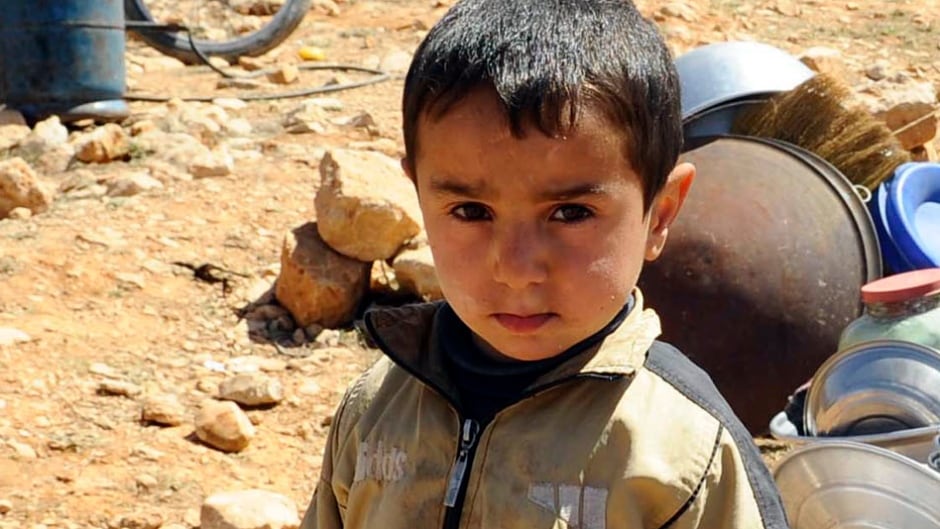 A Syrian refugee child who fled the violence from the Syrian town of Flita, near Yabroud, poses for a photograph at the border town of Arsal, in the eastern Bekaa Valley March 20, 2014.