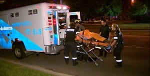 Paramedics load an injured victim into the back of an ambulance after a shooting early Tuesday morni