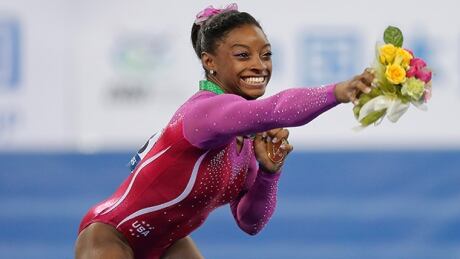 NANNING, CHINA - OCTOBER 10: Gold medalist Simone Biles of United States avoids a bee during the medal ceremony after the Women's All-Around Final in day four of the 45th Artistic Gymnastics World Championships at Guangxi Sports Center Stadium on October 10, 2014 in Nanning, China. biles-141010-620