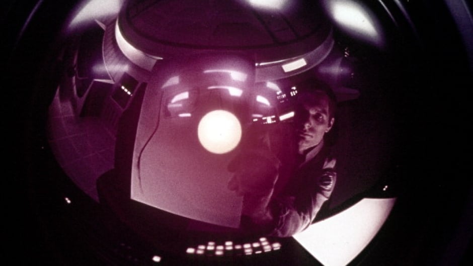 An astronaut looks at his reflection in a camera in a scene from the film '2001: A Space Odyssey', 1968.