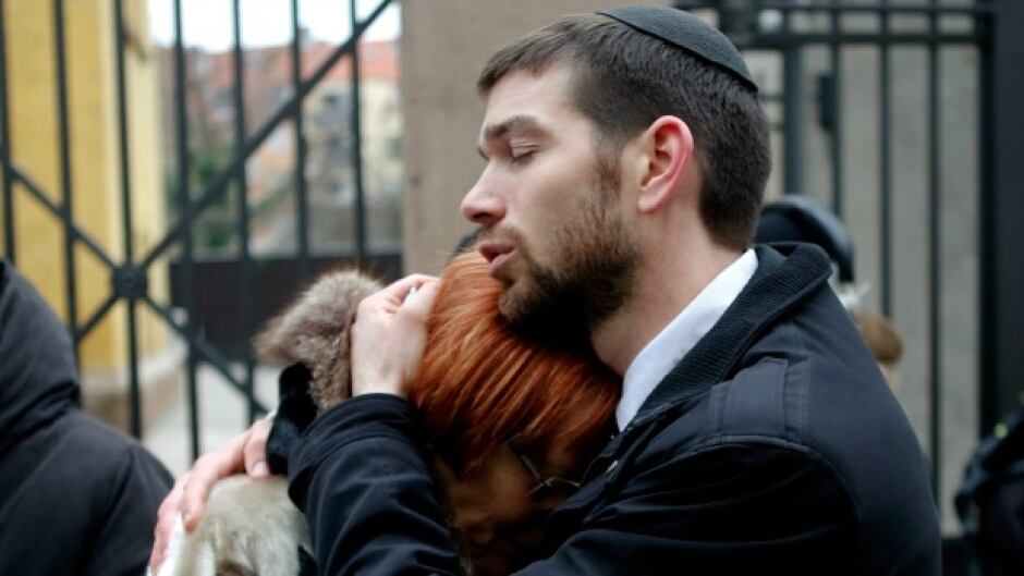 Denmark's chief rabbi, Jair Melchior, comforts a woman at a memorial site in Copenhagen.