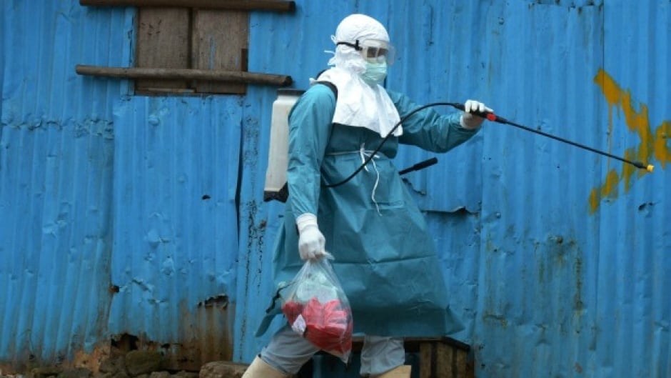 A medical worker of the John Fitzgerald Kennedy Hospital in Monrovia disinfects a wall.