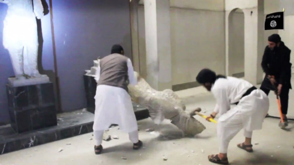 In this image made from video posted on a social media account affiliated with the Islamic State group on Thursday, Feb. 26, 2015, militants take sledgehammers to an ancient artifact in the Ninevah Museum in Mosul, Iraq.