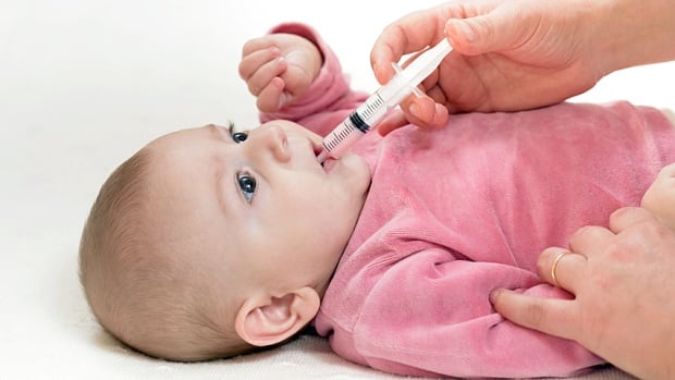 Baby receives medicine from a syringe