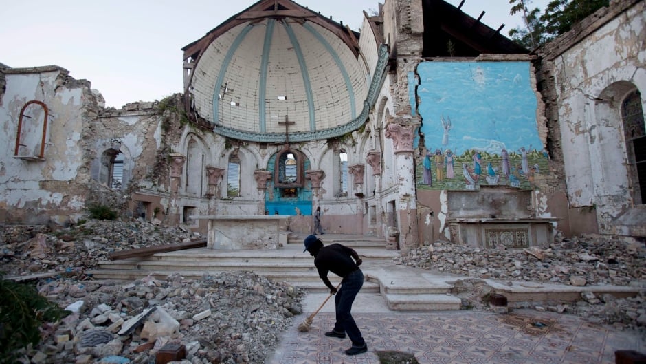 A man sweeps out the earthquake-damaged Santa Ana Catholic church, on Jan. 12, 2013 - three years after the disaster.