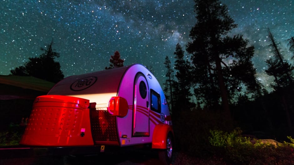 A chic teardrop camper sits under the light of the Milky Way at Kirkwood Lake in California.