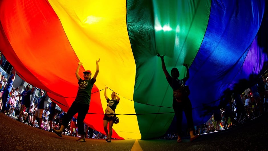 Marchers carry an oversized rainbow flag down Robson Street during the Vancouver Pride Parade in August 2014.