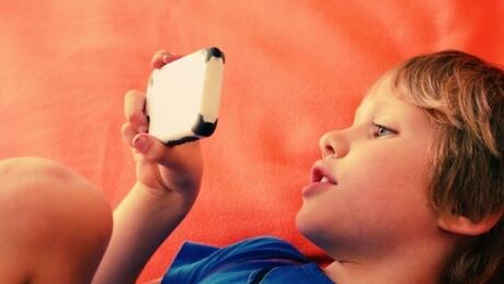 Child looks at mobile phone