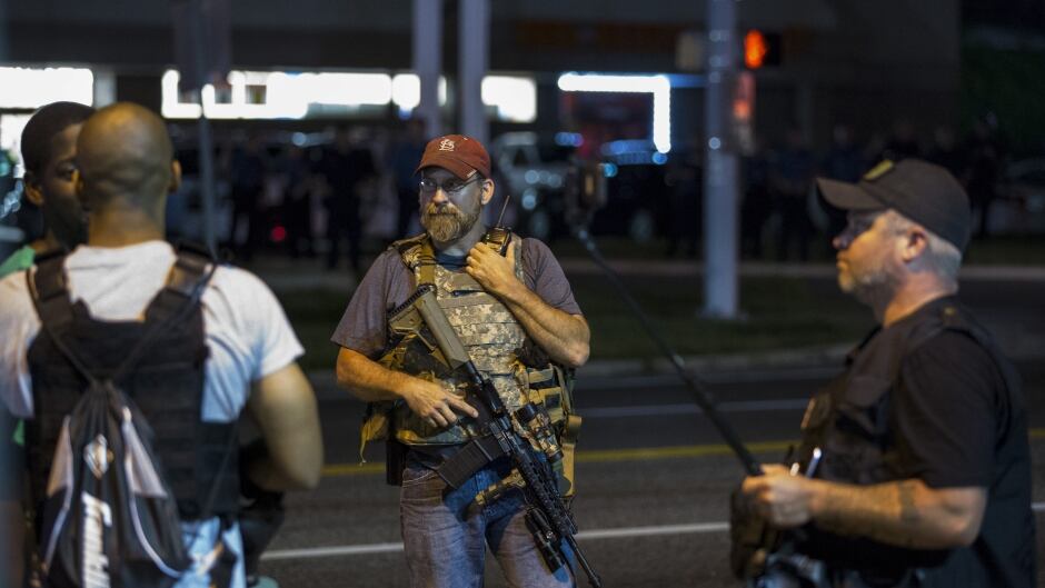 Members of the Oath Keepers walk with their personal weapons on the street during protests in Ferguson, Missouri August 11, 2015. Police in riot gear clashed with protesters who had gathered in the streets of Ferguson early on Tuesday to mark the anniversary of the police shooting of an unarmed black teen whose death sparked a national outcry over race relations. REUTERS/Lucas Jackson - RTX1NUGS