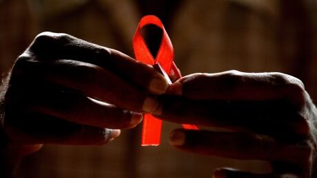 A HIV-positive person from the Support and Care Centre of the Sumanahalli Society prepares 'red ribbons' on the eve of World Aids Day in Bangalore on November 30, 2015. Globally about 36.9 million people are living with HIV including 2.6 million children, while the global response to HIV has averted 30 million new HIV infections and nearly 8 million deaths since 2000. World AIDS Day AIDS HIV India