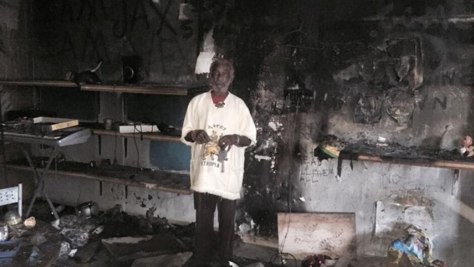 Lee "Scratch" Perry stands in his burned down studio, in Switzerland.