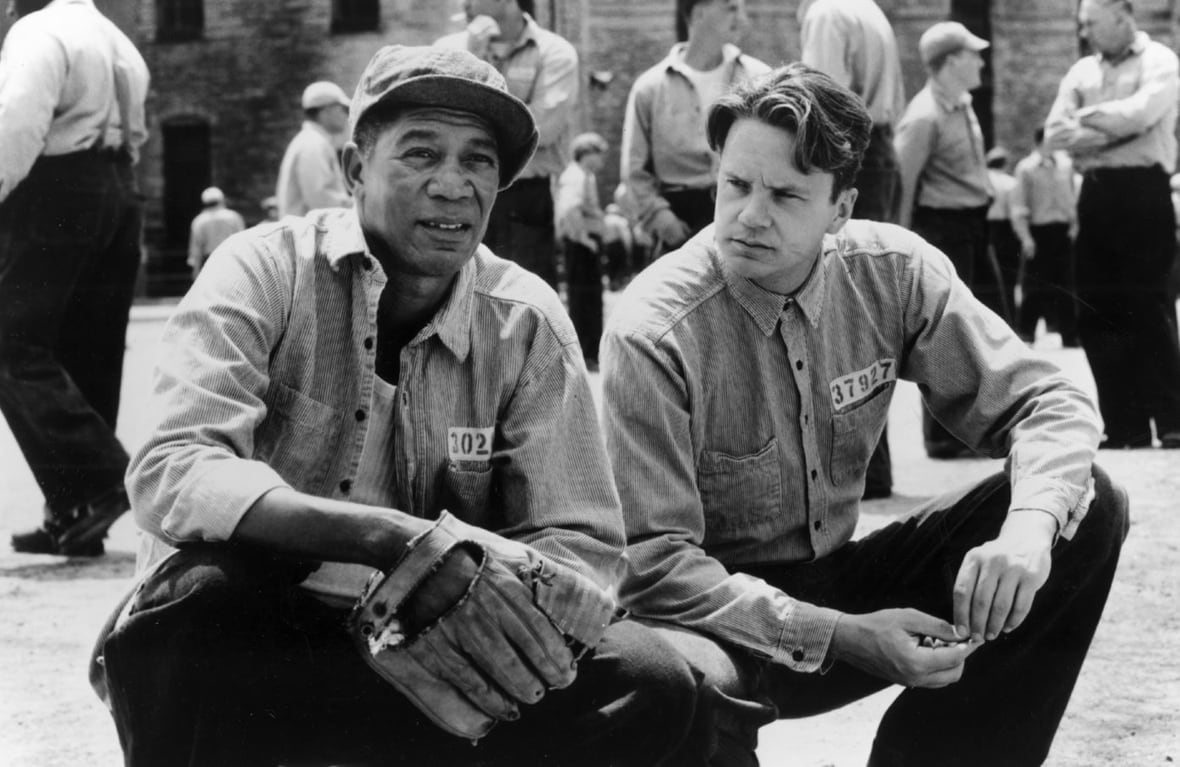 Morgan Freeman y Tim Robins se sientan junto a alguien.